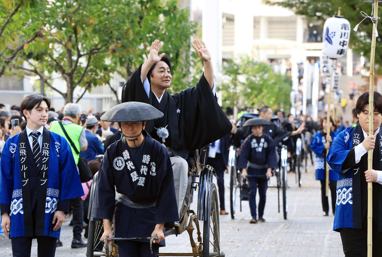 「立川立飛歌舞伎特別公演　お練り」で、人力車からファンに手を振る片岡愛之助。後方右は市川中車（撮影・浅見桂子）