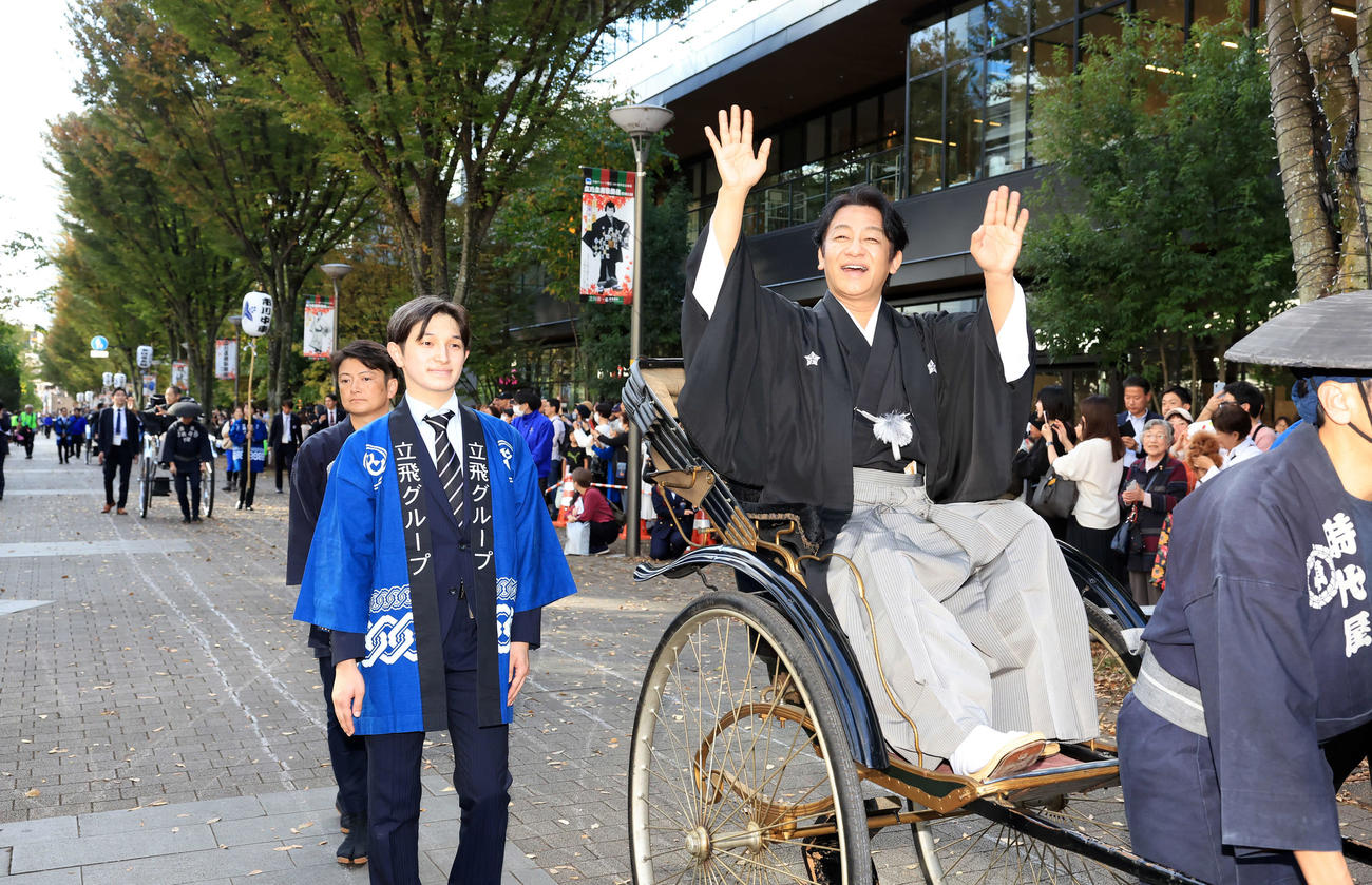 「立川立飛歌舞伎特別公演　お練り」で、人力車からファンに手を振る片岡愛之助。左後方には市川中車（撮影・浅見桂子）