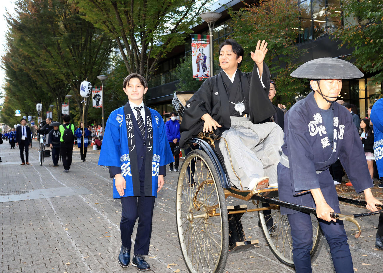 「立川立飛歌舞伎特別公演　お練り」で、人力車からファンに手を振る片岡愛之助。左後方には市川中車（撮影・浅見桂子）