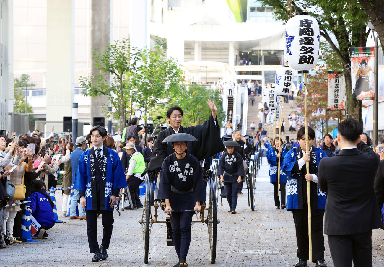 「立川立飛歌舞伎特別公演　お練り」で、人力車からファンに手を振る片岡愛之助。右後方には市川中車（撮影・浅見桂子）