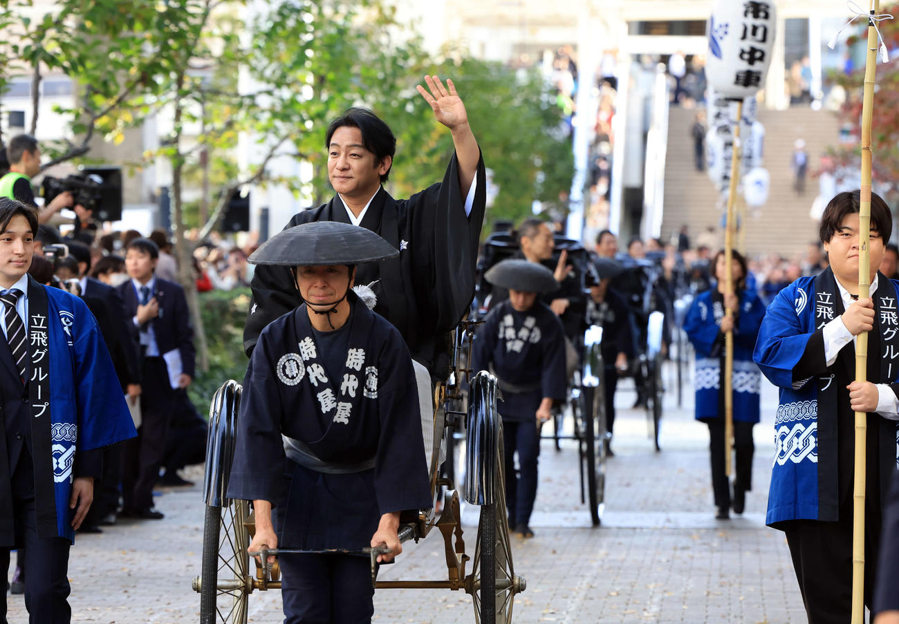 「立川立飛歌舞伎特別公演　お練り」で、人力車からファンに手を振る片岡愛之助。右後方には市川中車（撮影・浅見桂子）