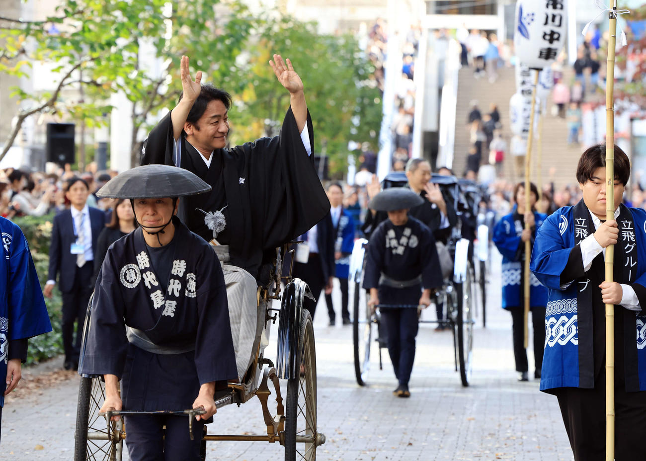 「立川立飛歌舞伎特別公演　お練り」で、人力車からファンに手を振る片岡愛之助。右後方には市川中車（撮影・浅見桂子）