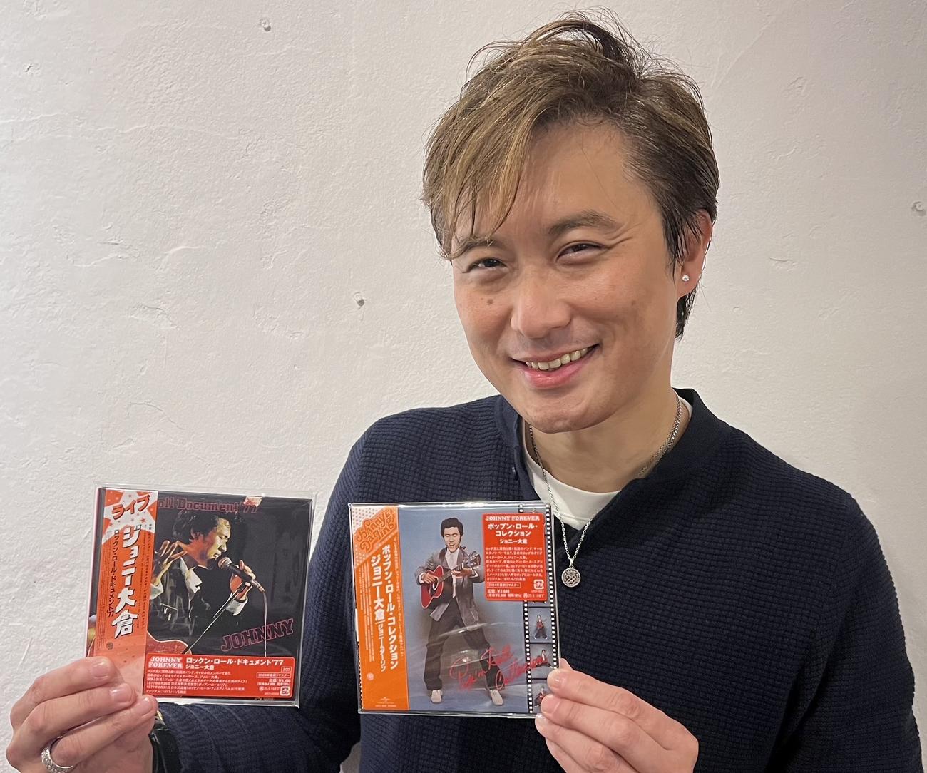 復活するジョニーさんのアルバム2作品を手にする長男のケニー大倉