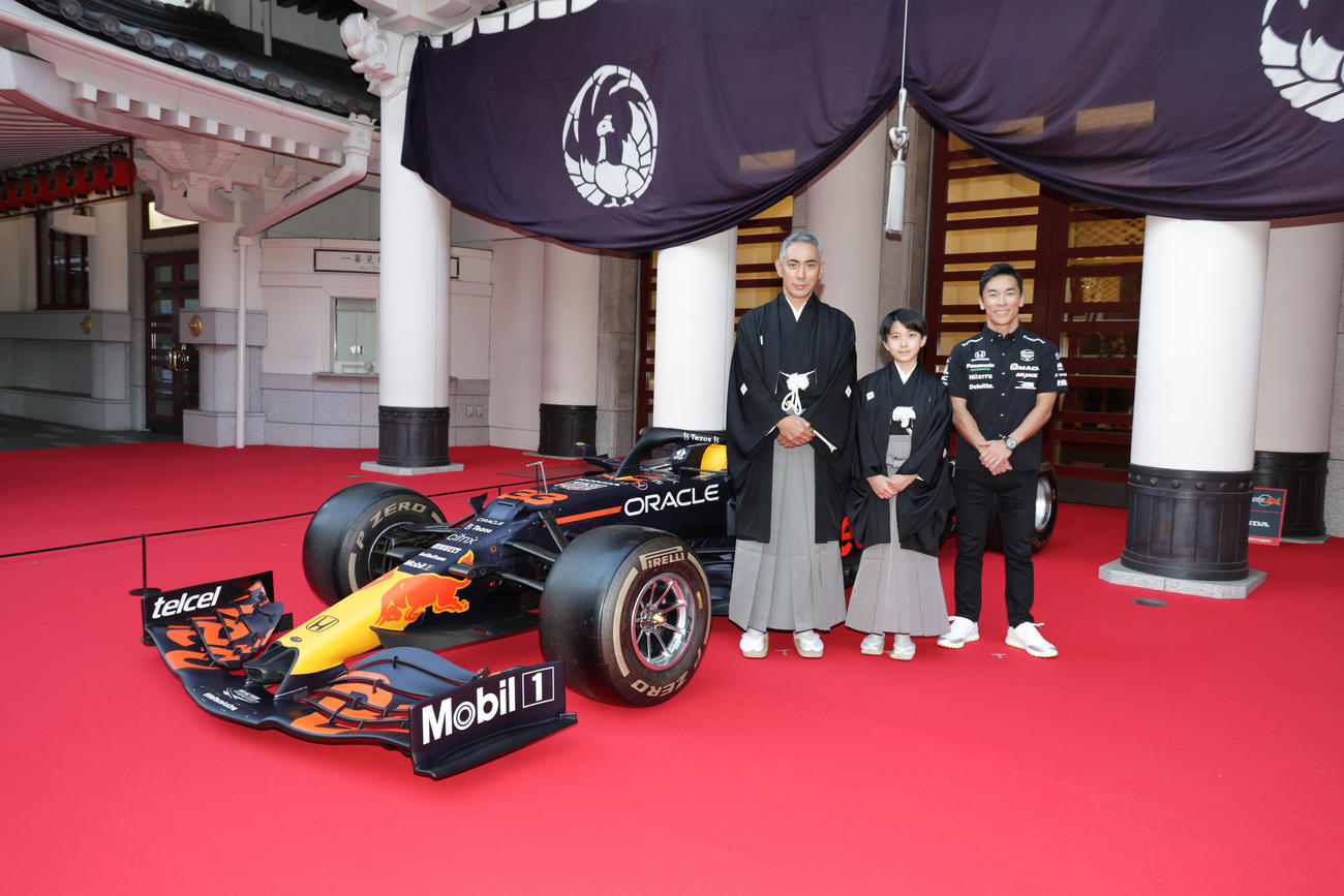 歌舞伎座正面に展示されたF1カーの前で記念撮影を行う、左から市川團十郎、市川新之助、佐藤琢磨氏（撮影・中島郁夫）