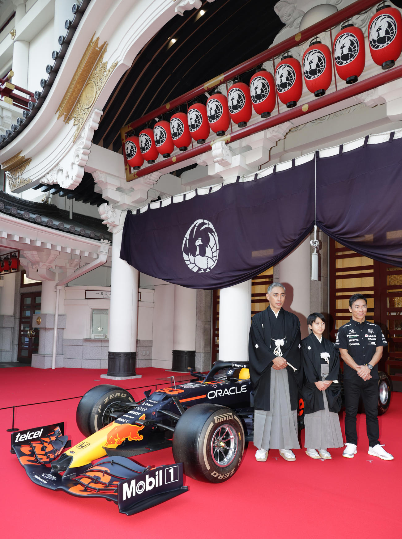 歌舞伎座正面に展示されたF1カーの前で記念撮影を行う、左から市川團十郎、市川新之助、佐藤琢磨氏（撮影・中島郁夫）