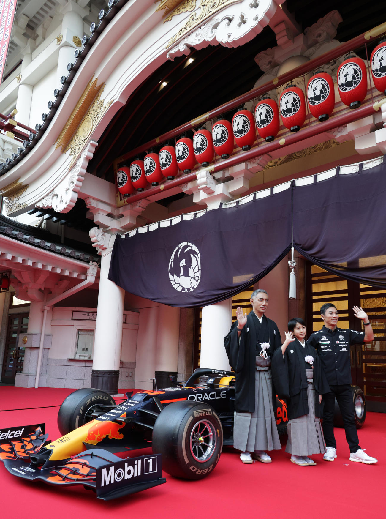 歌舞伎座正面に展示されたF1カーの前で記念撮影を行う、左から市川團十郎、市川新之助、佐藤琢磨氏（撮影・中島郁夫）