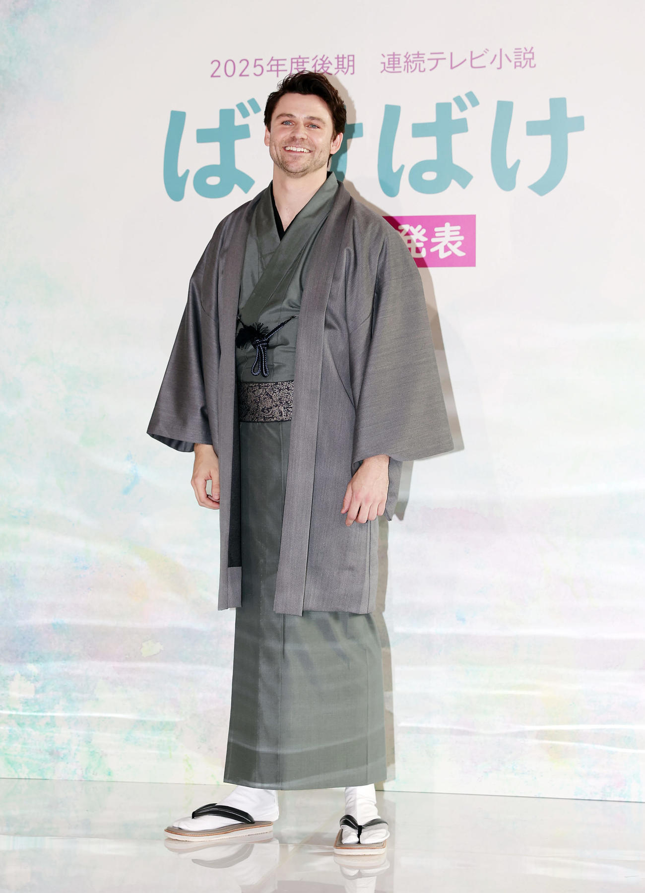 2025年後期連続テレビ小説「ばけばけ」の出演者発表会見で登壇し、フォトセッションで笑顔を見せる、ヒロインの夫・ヘブン役のトミー・バストウ（撮影・前田充）