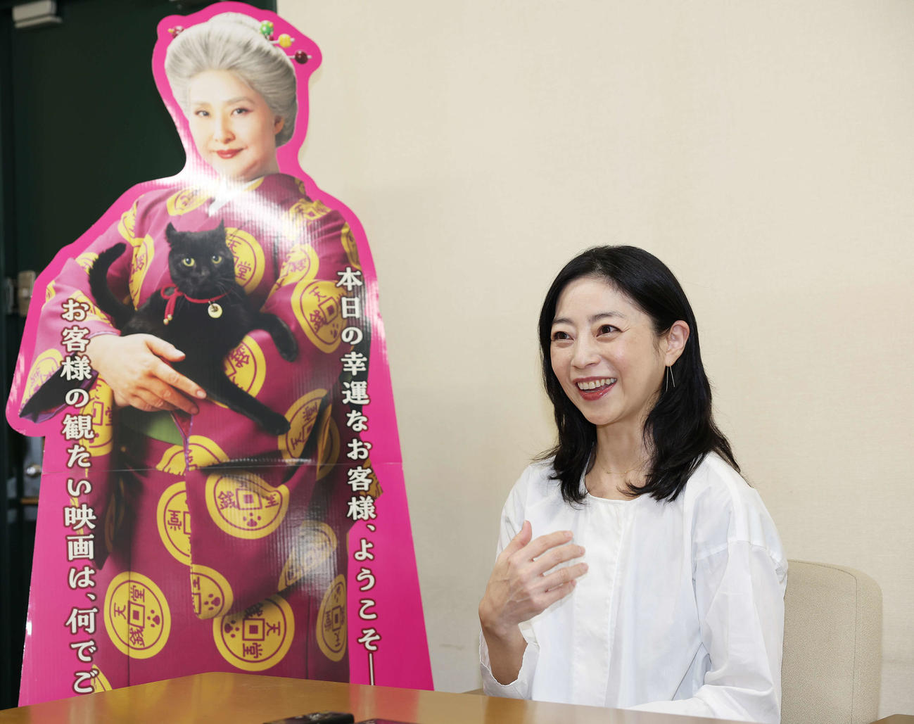 映画「ふしぎ駄菓子屋　銭天堂」で紅子役を演じる天海祐希のパネルの隣で笑顔でインタビューに答える田中里衣（撮影・宮地輝）