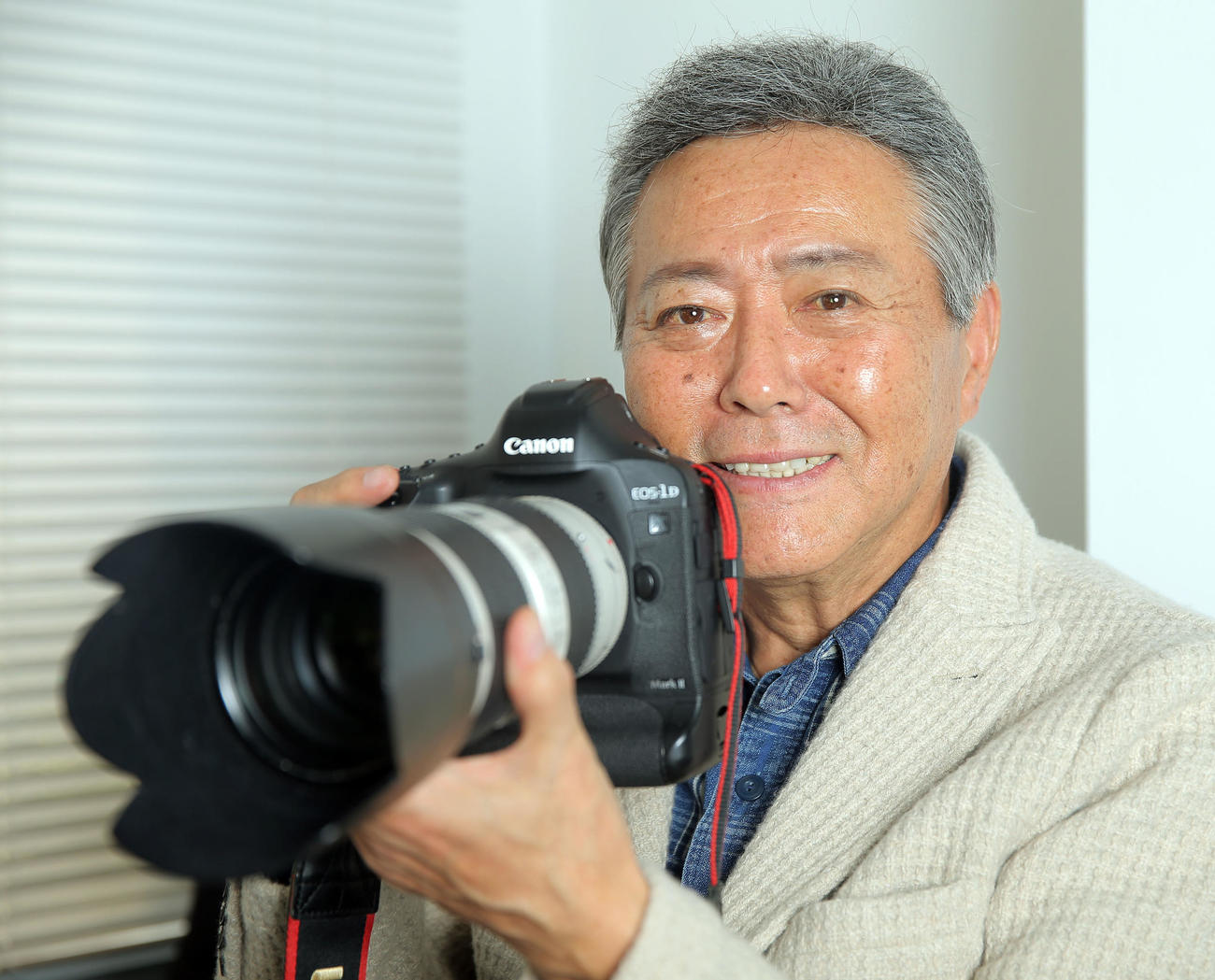 カメラを手に笑顔を見せる小倉智昭さん（2016年11月22日撮影）