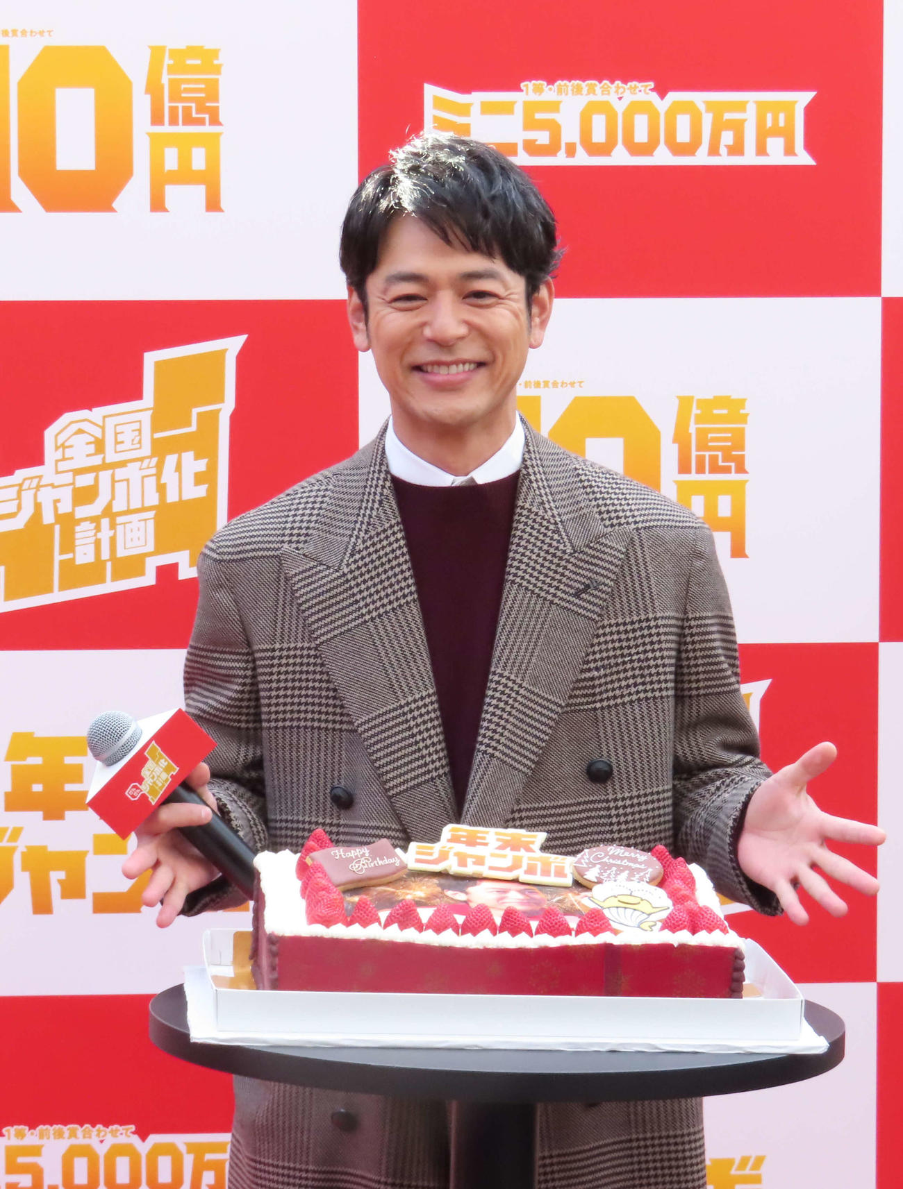 「年末ジャンボ宝くじ」「年末ジャンボミニ」全国だんだんジャンボ化計画イベントで、誕生日ケーキを前に笑顔を見せる妻夫木聡