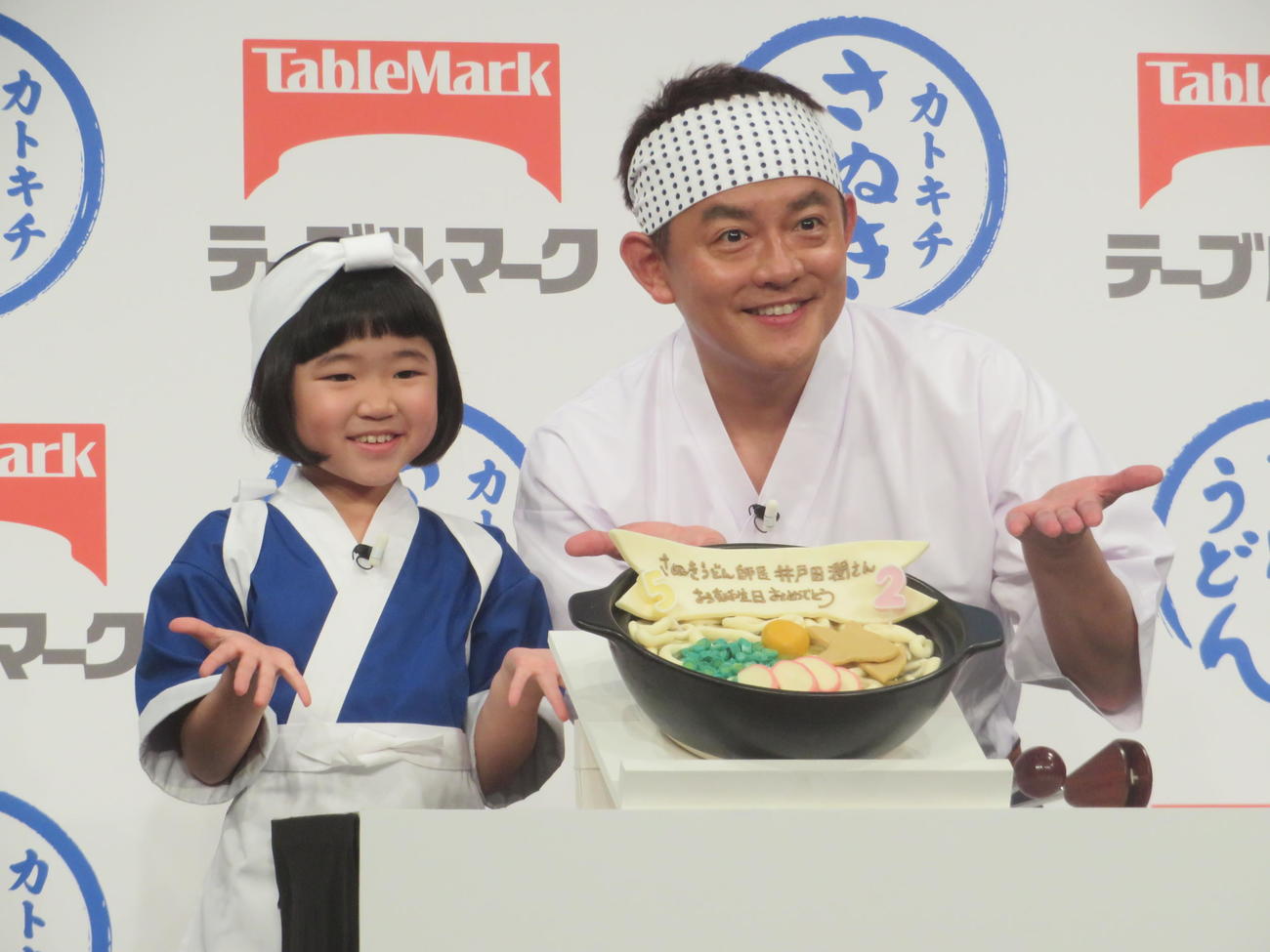 サプライズで用意された“うどん”誕生日ケーキを披露する永尾柚乃（左）と井戸田潤
