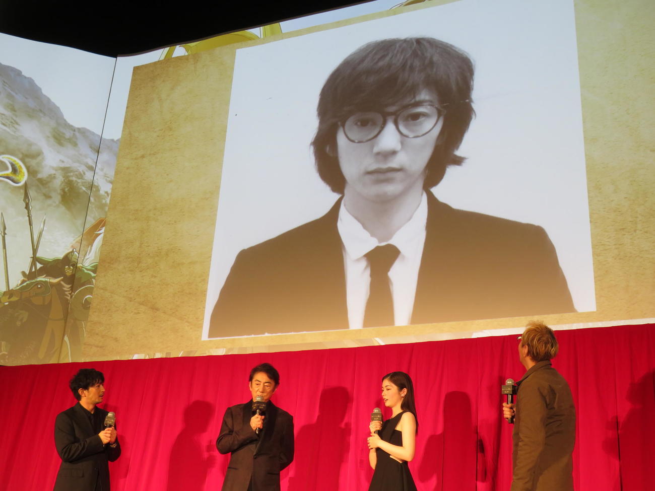 「ロード・オブ・ザ・リング／ローハンの戦い」ジャパンプレミアで市村正親の“始まり”の写真を見る、左から津田健次郎、市村正親、小芝風花、神山健治監督