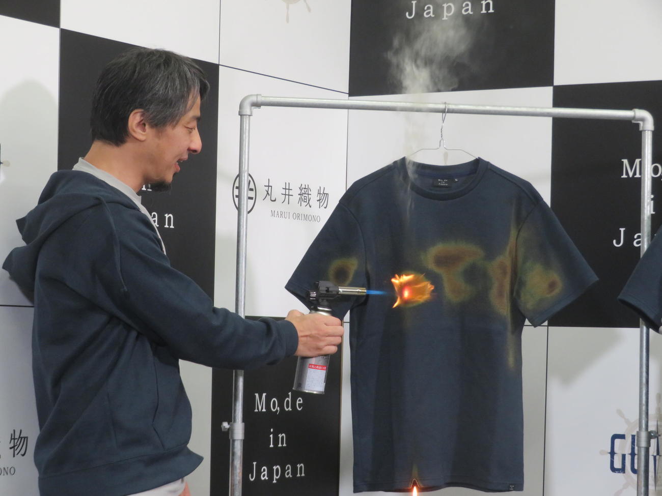 新会社商品「Mo，de in Japan」発表会のデモでTシャツをバーナーであぶるひろゆき氏