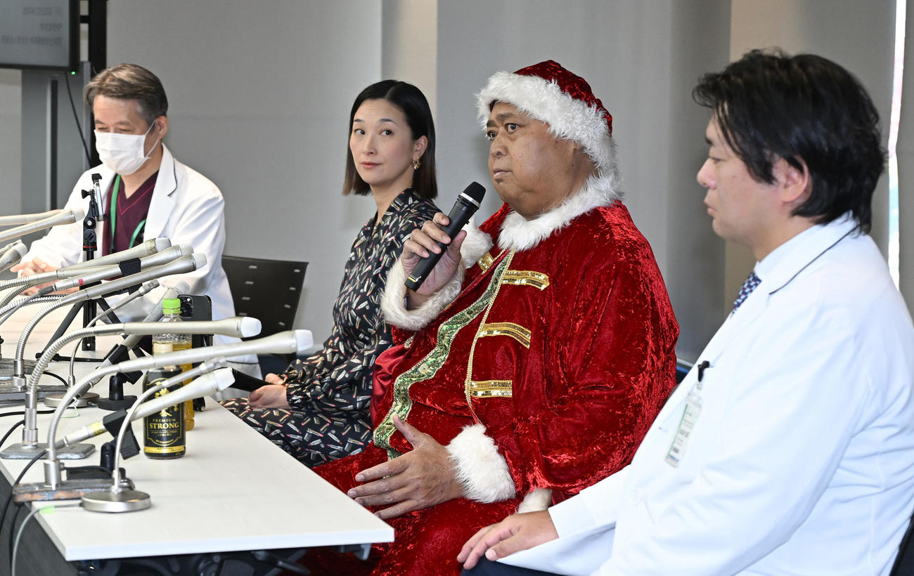 千絵夫人らと退院報告の記者会見する小錦八十吉。左は成泌尿器科の田邊総括部長、右は腎移植外科の大久保恵太部長（撮影・千葉一成）
