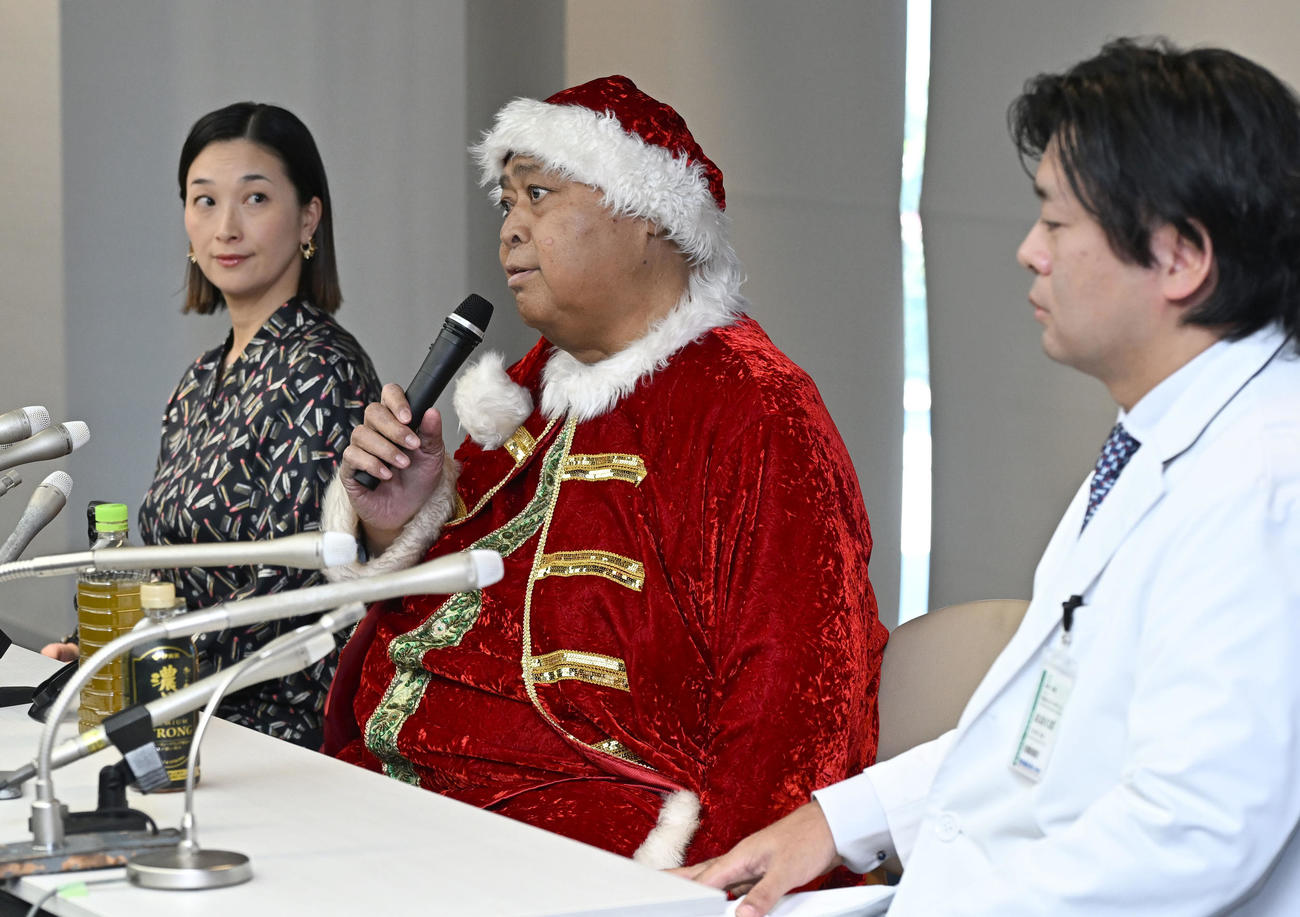 退院報告記者会見する小錦八十吉。左は千絵夫人、右は腎移植外科の大久保部長（撮影・千葉一成）