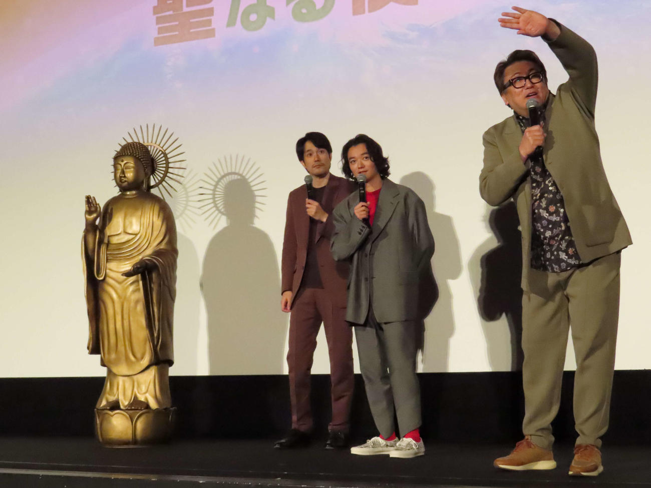 「聖☆おにいさん　THE MOVIE～ホーリーメンVS悪魔軍団～」聖なる夜の大感謝祭で、特賞の仏像が当たった来場者に持ち帰りの可否を聞く、左から松山ケンイチ、染谷将太、福田雄一監督