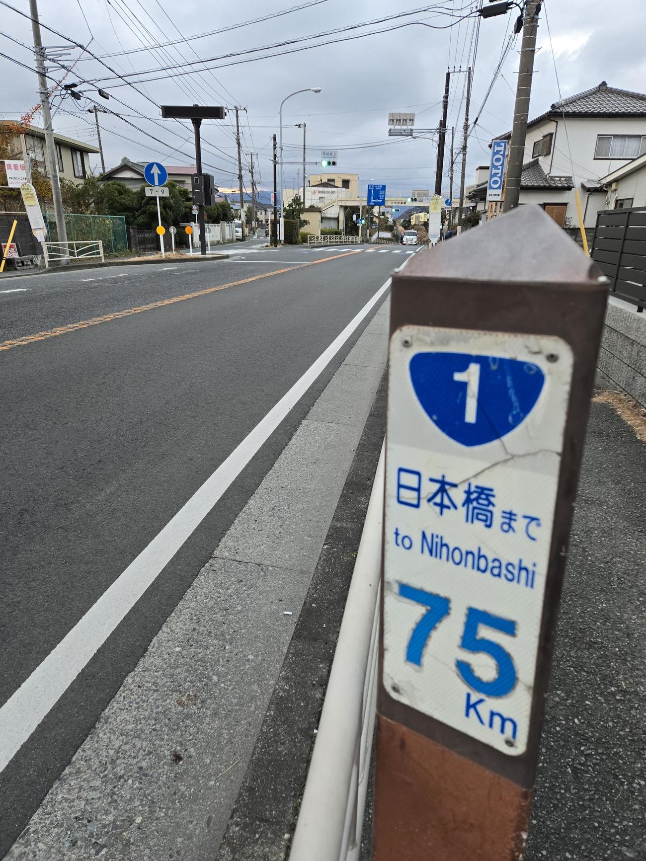 フリーザ軍団が沿道で声援する7区二宮町押切坂を登り切ると日本橋まで75キロの国道1号道標が打たれている（撮影・寺沢卓）