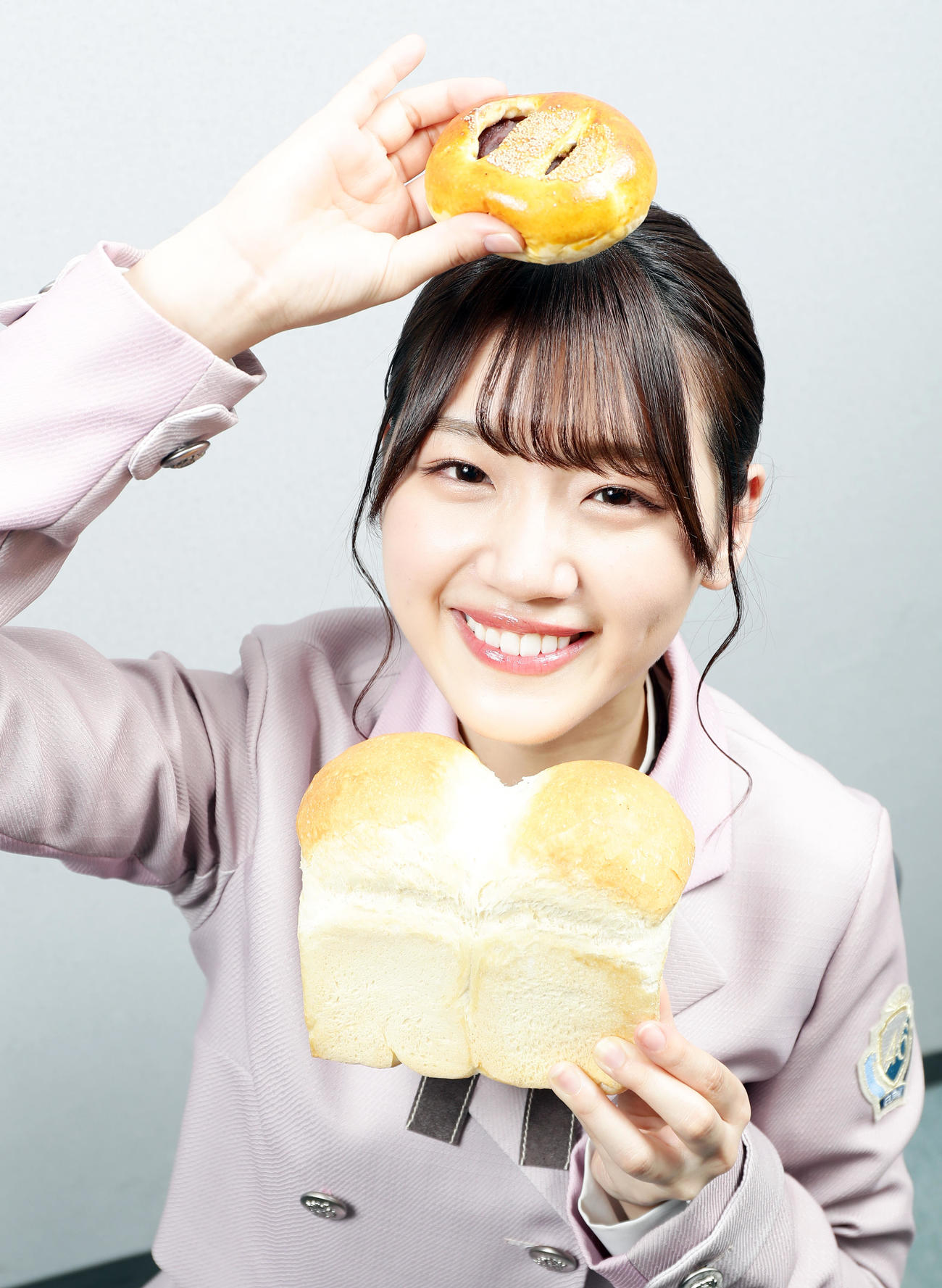 「みーぱん」と呼ばれる由来は、大のパン好きから。あんパンと食パンに挟まれ、幸せな笑顔を見せる日向坂46の佐々木美玲（2020年3月撮影）
