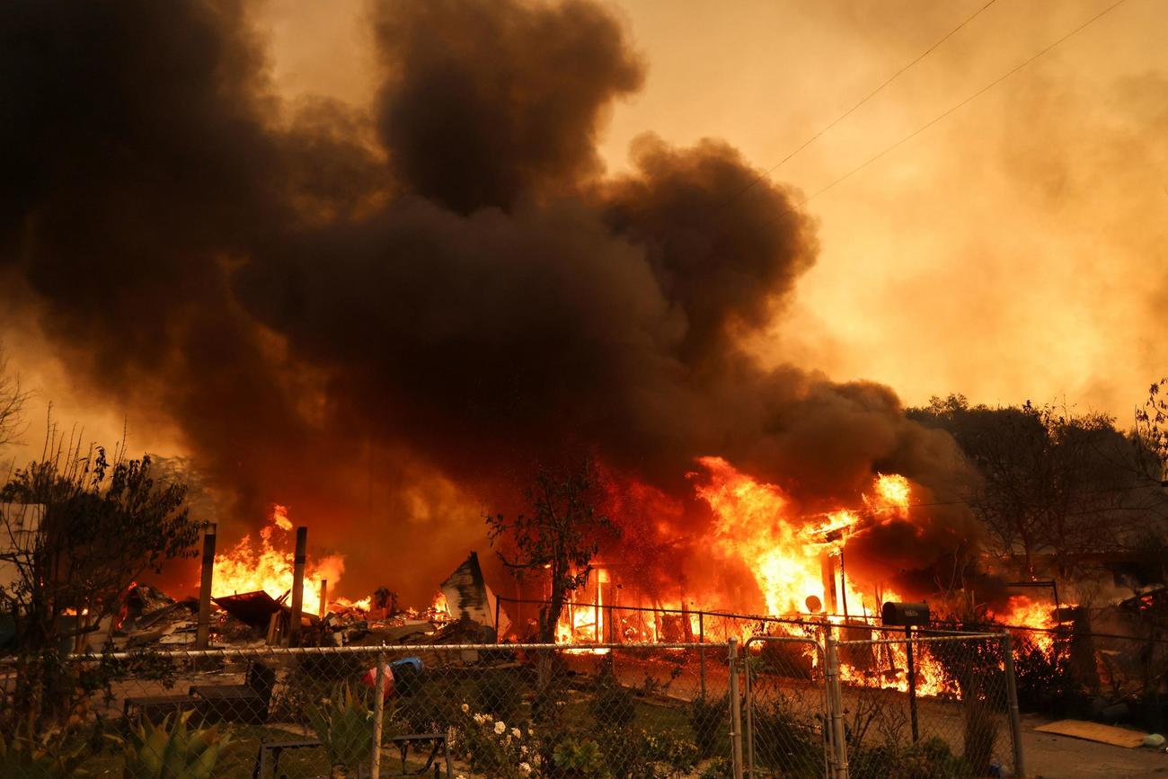 ロサンゼルス地域での山火事で燃える建物（ロイター）
