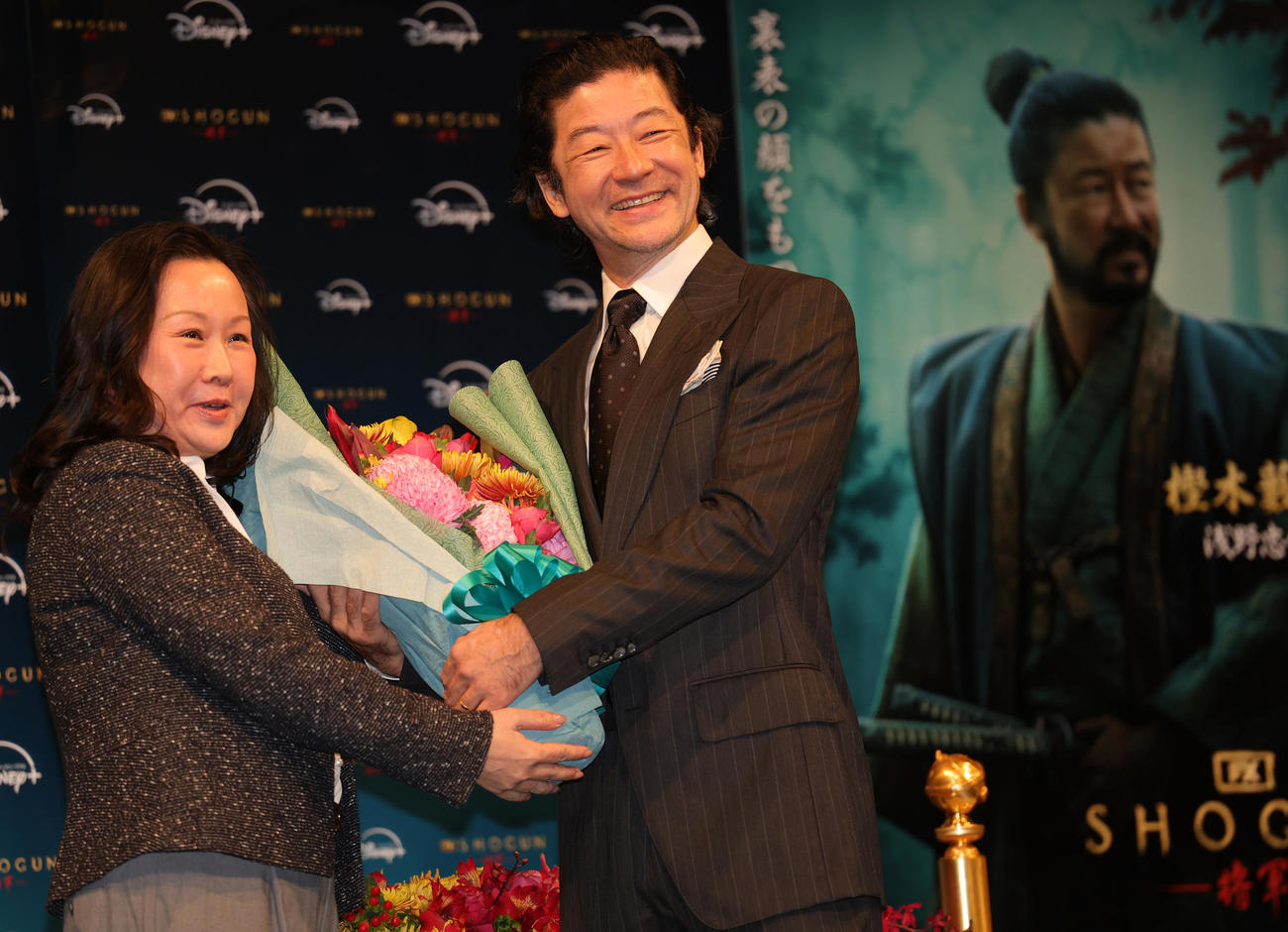 「SHOGUN　将軍」のゴールデングローブ賞4冠受賞記念会見に登場し、ウォルト・ディズニー・ジャパンのキャロル・チョイ社長（左）から祝福される助演男優賞の浅野忠信（撮影・野上伸悟）