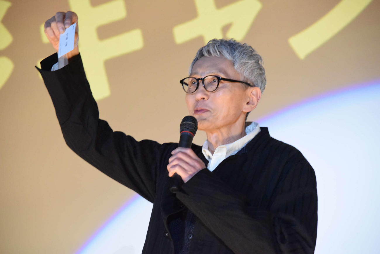 「劇映画　孤独のグルメ」の舞台あいさつに登場し、井の頭五郎の名刺を見せる松重豊（撮影・阪口孝志）