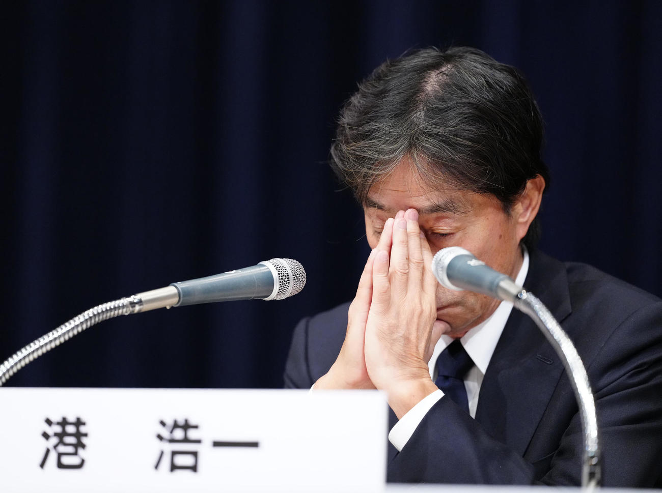 記者会見中、顔の前で手を合わせるフジテレビ港浩一社長＝27日午後11時49分（撮影・江口和貴）