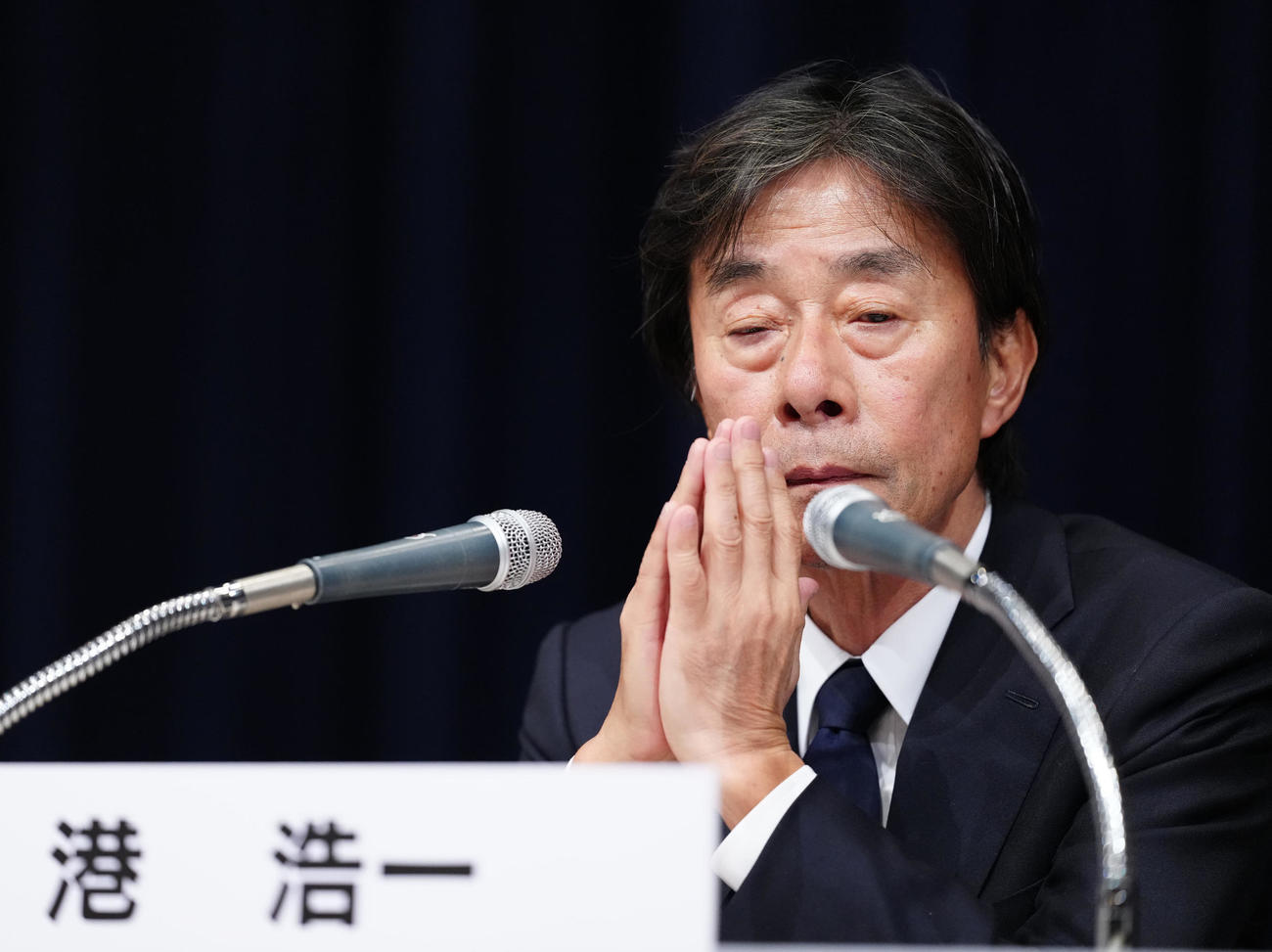 記者会見中、顔の前で手を合わせるフジテレビ港浩一社長＝27日午後11時49分（撮影・江口和貴）