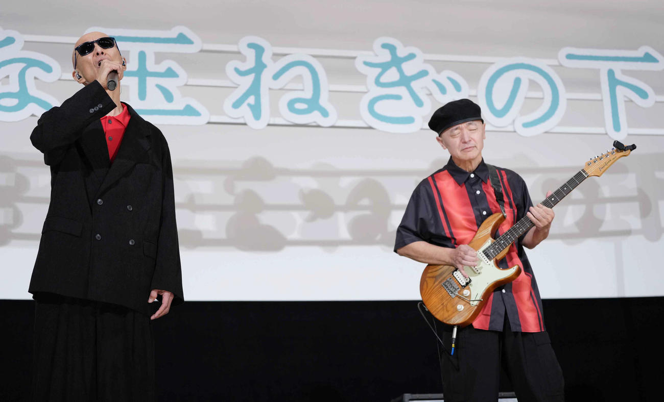 映画「大きな玉ねぎの下で」初日舞台あいさつに臨みサプライズで登壇し熱唱する爆風スランプのサンプラザ中野くん。右はパッパラー河合（撮影・小沢裕）
