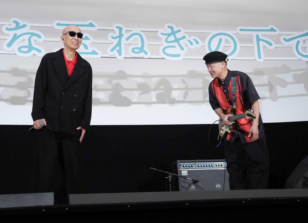 映画「大きな玉ねぎの下で」初日舞台あいさつに臨みサプライズで登壇した爆風スランプのサンプラザ中野くんは熱唱後詰め掛けた観客に頭を下げて感謝する。右はパッパラー河合（撮影・小沢裕）