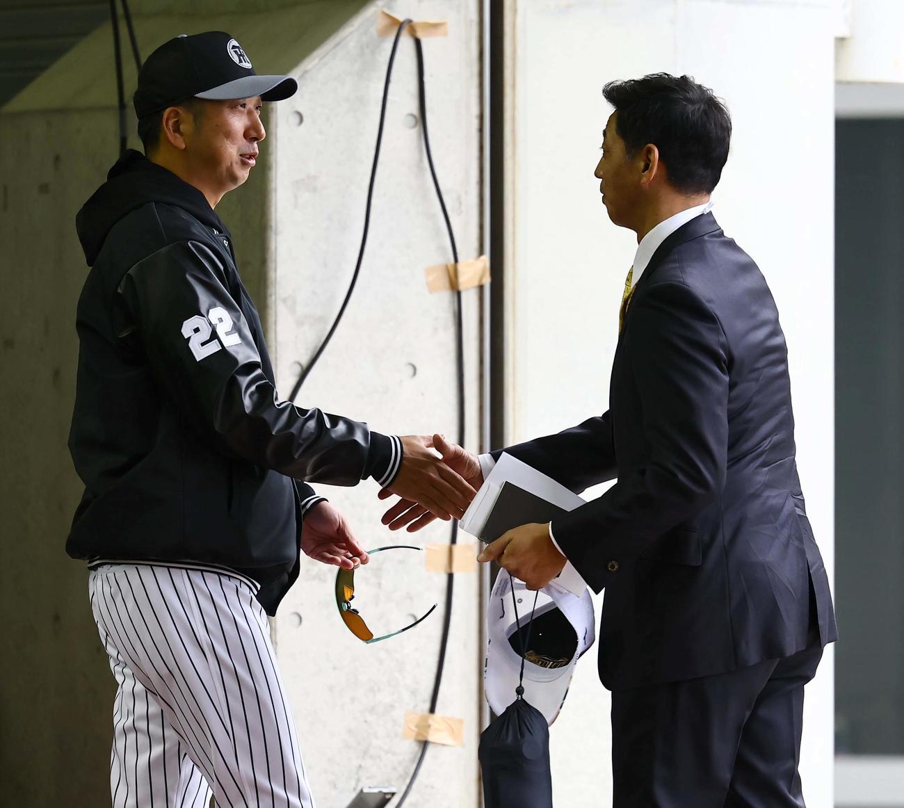 25年2月6日　藤川監督（左）はキャンプ地を訪れた田口氏と握手を交わす（撮影・上田博志）