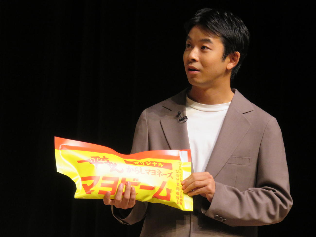 「明星　一平ちゃん夜店の焼そば」発売30周年記念発表会で巨大マヨビームの袋を手にする仲野太賀