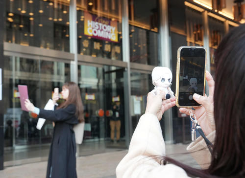 休館前の最終公演が行われた帝国劇場前で思い出の品物を手に写真撮影をするファン（撮影・小沢裕）