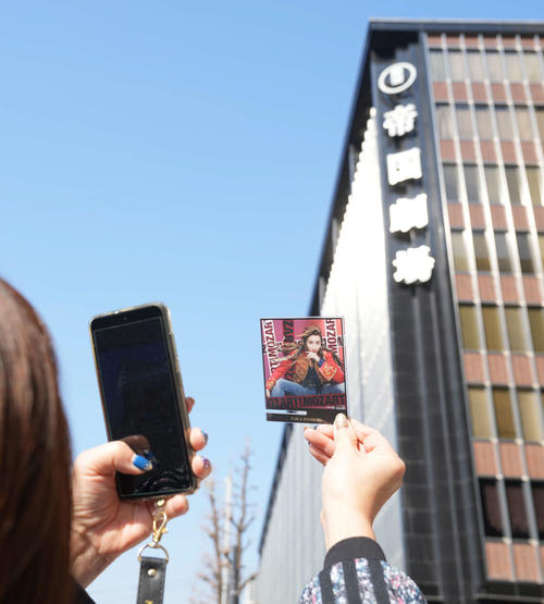 休館前の最終公演が行われた帝国劇場前で思い出の品物を手に写真撮影をするファン（撮影・小沢裕）