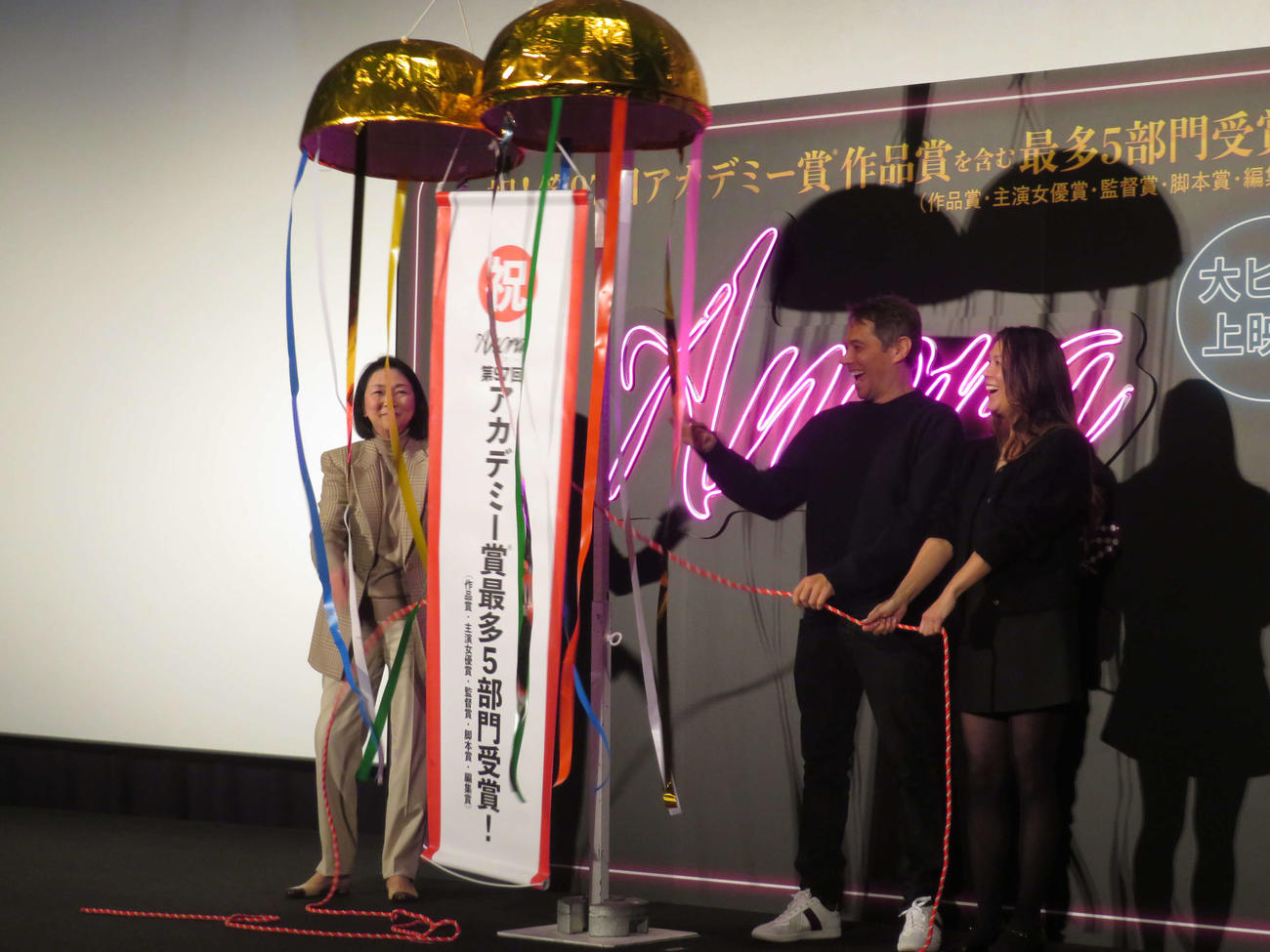 くす玉の祝福を受けるベイカー監督（中央）とサマンサ・クァンプロデューサー、左端は梶芽衣子