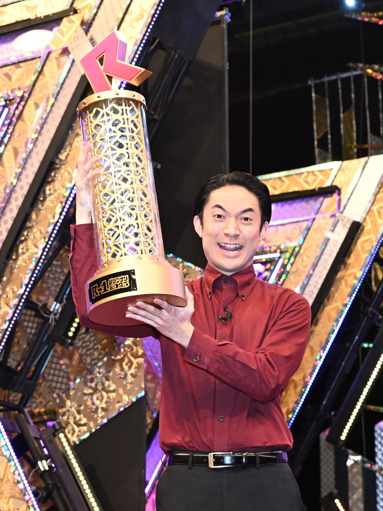 「R－1グランプリ2025」でファイナルステージを勝ち抜き優勝し、トロフィーを掲げる友田オレ（撮影・千葉一成）
