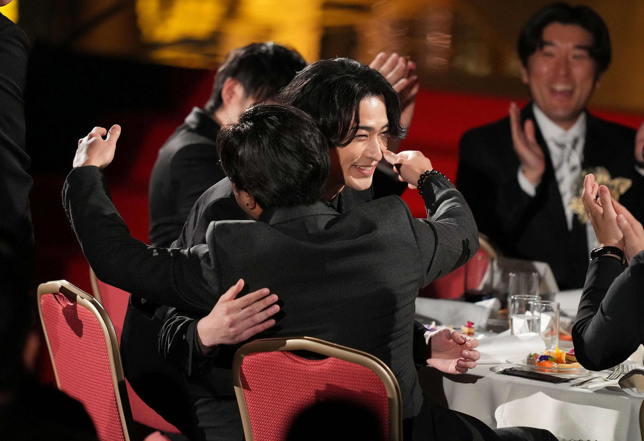 最優秀主演男優賞に選ばれた横浜流星（中央）は関係者と笑顔で抱き合う（撮影・横山健太）