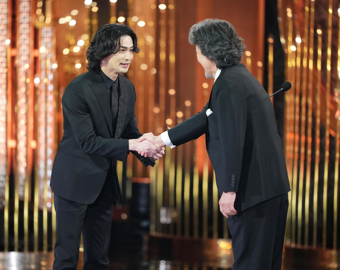 最優秀主演男優賞に選ばれた横浜流星（左）はプレゼンターの役所広司と笑顔で握手を交わす（撮影・横山健太）
