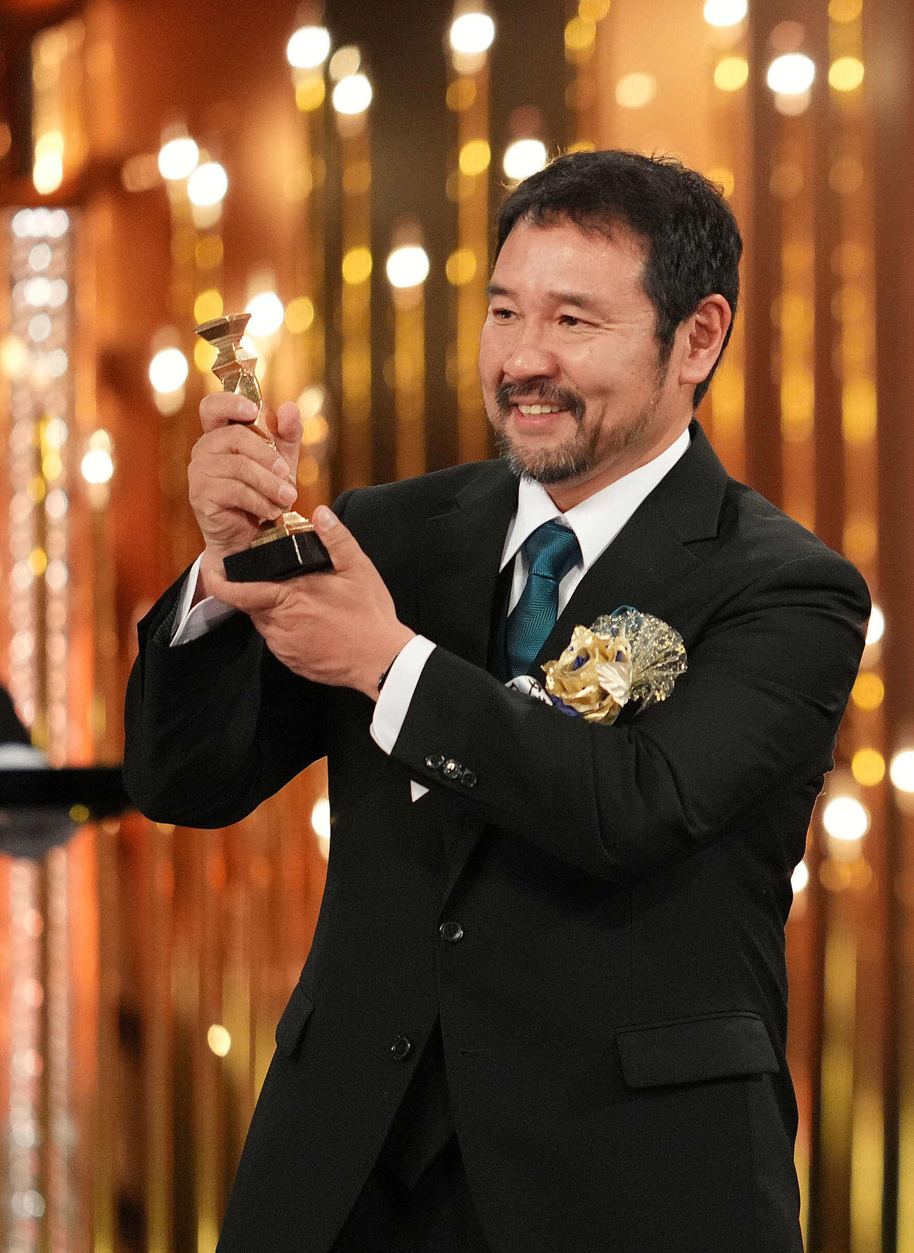 最優秀作品賞に選ばれトロフィーを掲げる映画「侍タイムスリッパー」の安田淳一監督（撮影・横山健太）