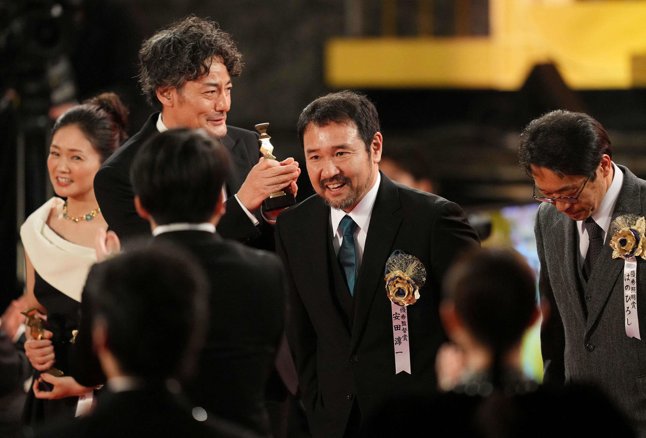最優秀作品賞に選ばれ拍手を受けながら降壇する映画「侍タイムスリッパー」の安田淳一監督（中央）（撮影・横山健太）