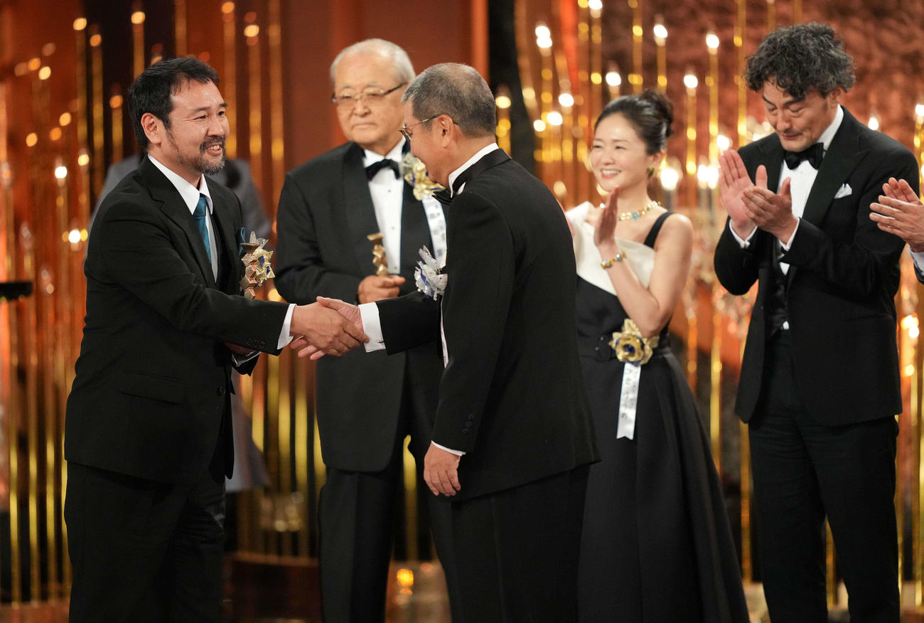 最優秀作品賞に選ばれトロフィーを受け取る映画「侍タイムスリッパー」の安田淳一監督（左）（撮影・横山健太）
