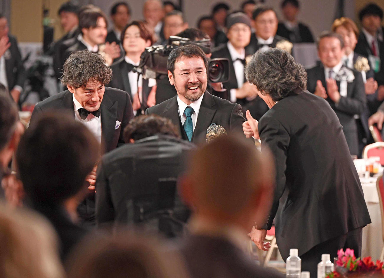 最優秀作品賞に輝き、役所広司（右）に祝福される「侍タイムスリッパー」の、左から山口馬木也、安田淳一監督（代表撮影）