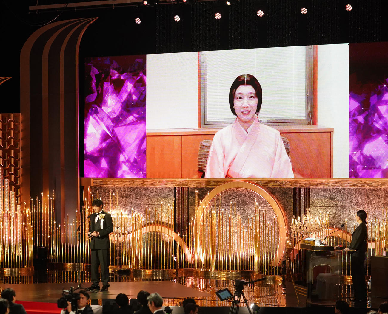 最優秀助演女優賞に選ばれ代理でトロフィーを受け取った藤井道人監督（手前左）とリモート出演で笑顔を見せる吉岡里帆（撮影・横山健太）