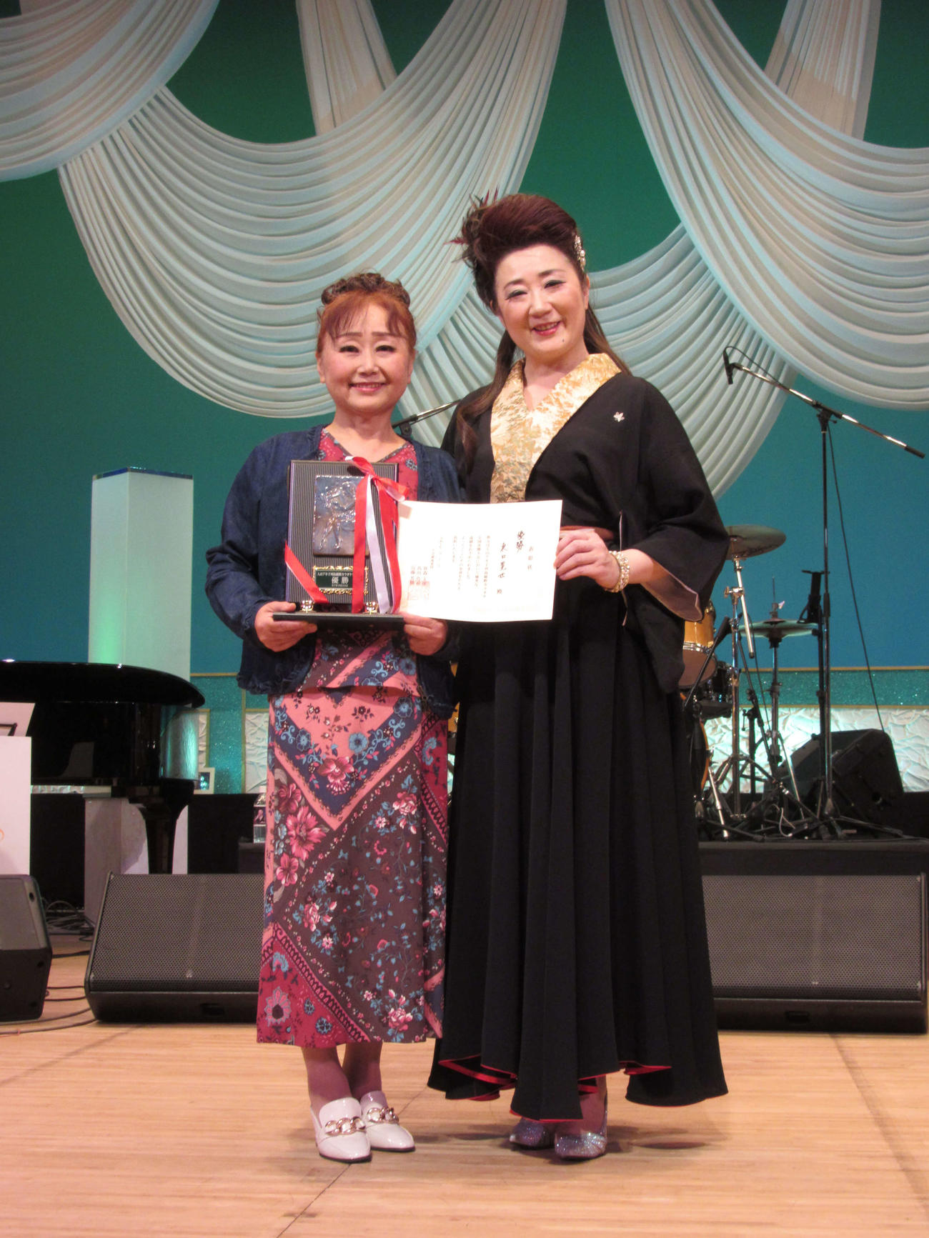 入山アキ子（右）のカラオケ全国決勝大会で優勝した東口晃世さん（23日、埼玉・所沢文化センターミューズ）