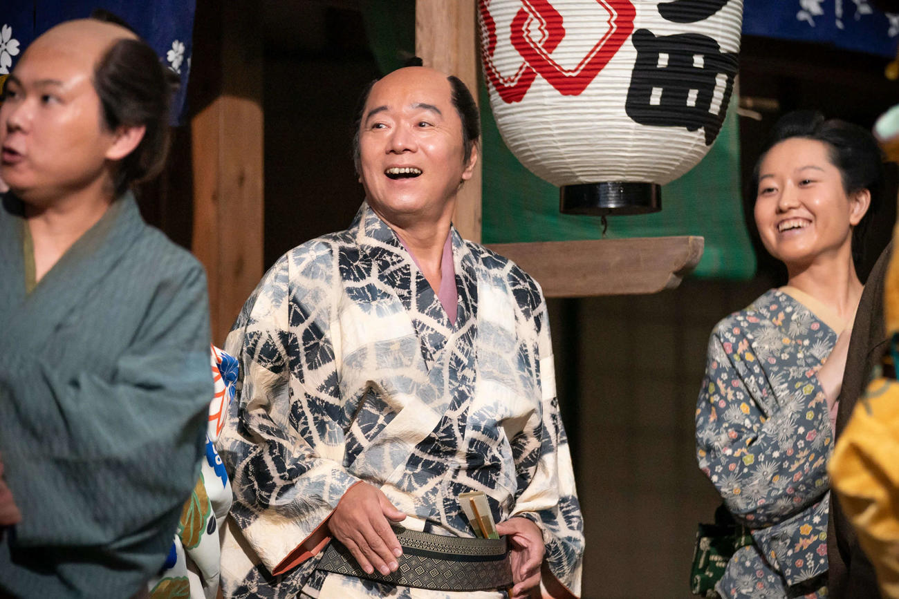 「べらぼう～蔦重栄華乃夢噺～」の場面写真。平沢常富（朋誠堂喜三二）役の尾美としのり（中央）
