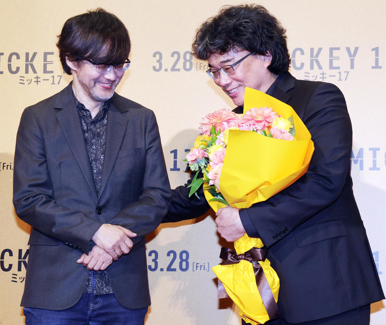 「ミッキー17」ジャパンプレミアに登場し、山崎貴監督（左）から花束をもらうポン・ジュノ監督（撮影・野上伸悟）