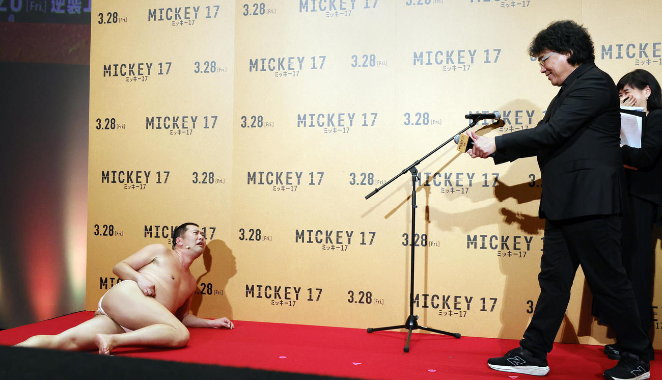 「ミッキー17」ジャパンプレミアに登場したとにかく明るい安村（左）は、ポン・ジュノ監督の前で「プリントされたときのミッキーの全裸ポーズ」を披露する（撮影・野上伸悟）