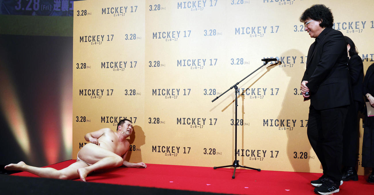「ミッキー17」ジャパンプレミアに登場したとにかく明るい安村（左）は、ポン・ジュノ監督の前で「プリントされたときのミッキーの全裸ポーズ」を披露する（撮影・野上伸悟）