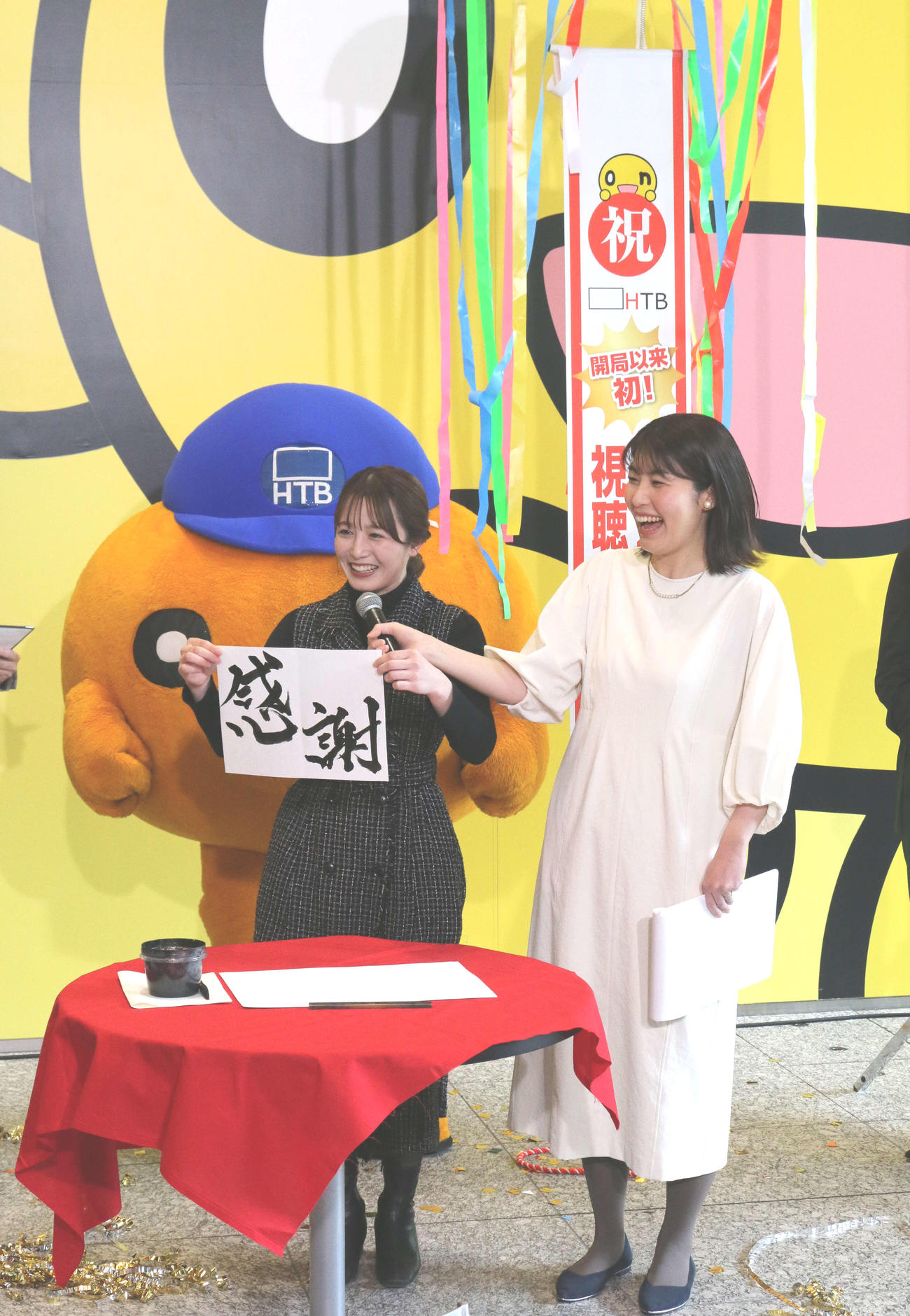 HTBの福地妃菜美アナ（左）は得意の書道で「感謝」の文字を披露。右は室岡里美アナ