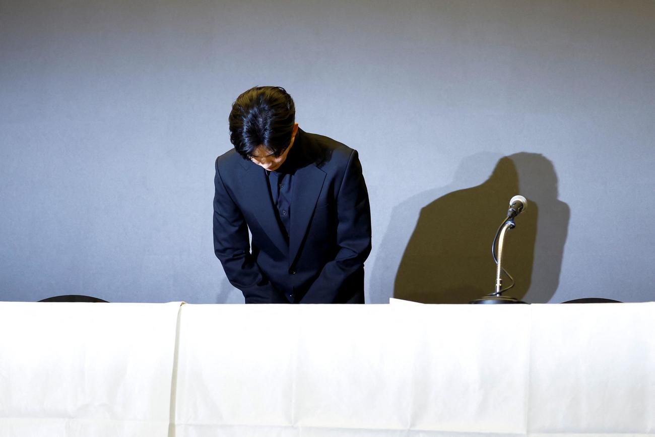 会見で頭を下げるキム・スヒョン（ロイター）