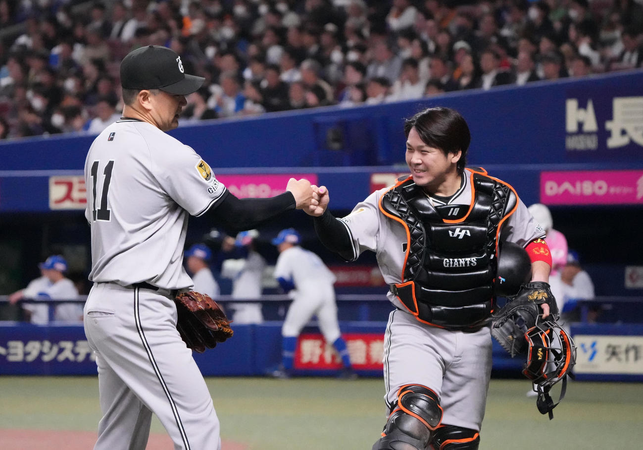 中日対巨人　4回終了、甲斐とタッチを交わしベンチへ戻る田中将（左）（2025年4月3日撮影）
